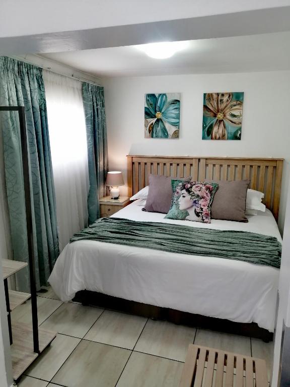 a bedroom with a large bed with two pillows at Sleep@161 Benade Drive in Bloemfontein