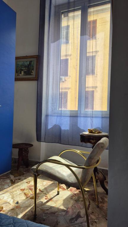 a chair sitting in a room with a window at AA Central Station Historical center in Palermo