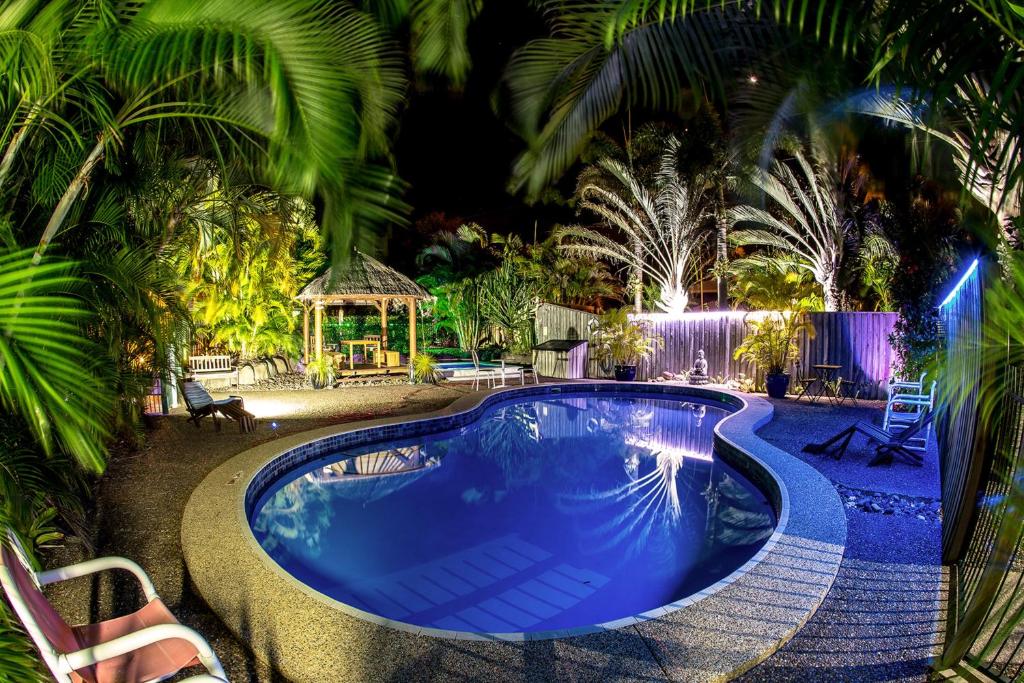 uma piscina com um gazebo e palmeiras em Pialba Motor Inn em Hervey Bay