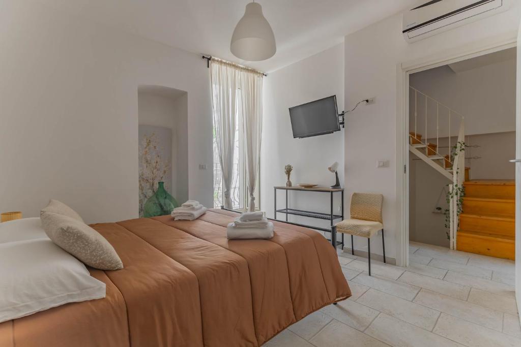 a bedroom with a large bed and a television at Maison de Sisine in Capurso