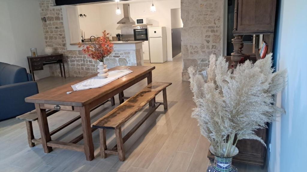 a wooden table and bench in a living room at Maison cosy esprit campagne in Luçon