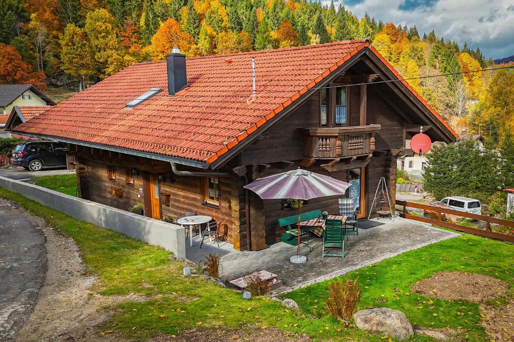 a wooden house with an umbrella in front of it at Ferienhaus Schachtenbach in Bayerisch Eisenstein