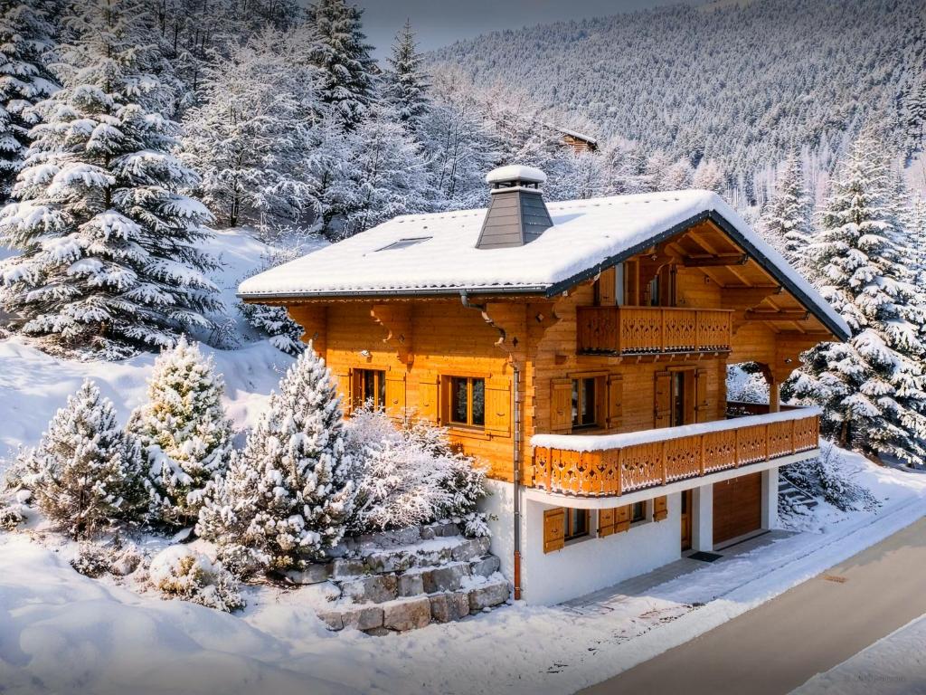 a log cabin in the snow with trees at Chalet Roche de Pierre - OVO Network in Saint-Jean-d'Aulps