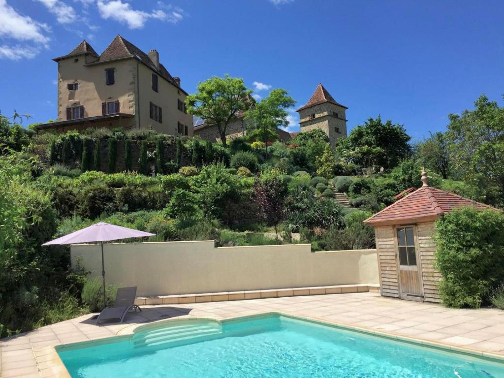 a swimming pool in front of a house and a building at La Source de Diège in Loupiac