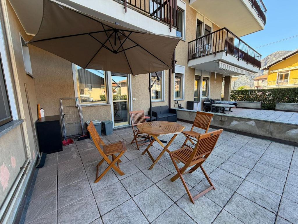 a patio with a table and chairs and an umbrella at La Casa Del Tasso in Feriolo