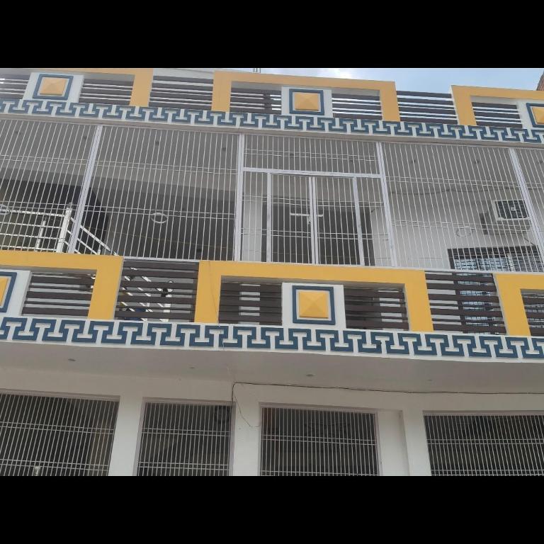a yellow and white building with many windows at narayan home stay in Ayodhya