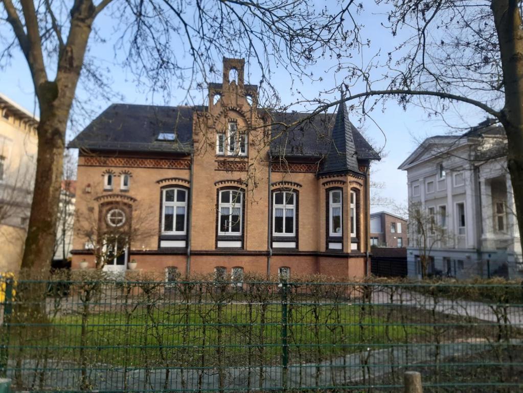 an old brick building with a clock tower on top at Meeresleuchten 1 in Emden