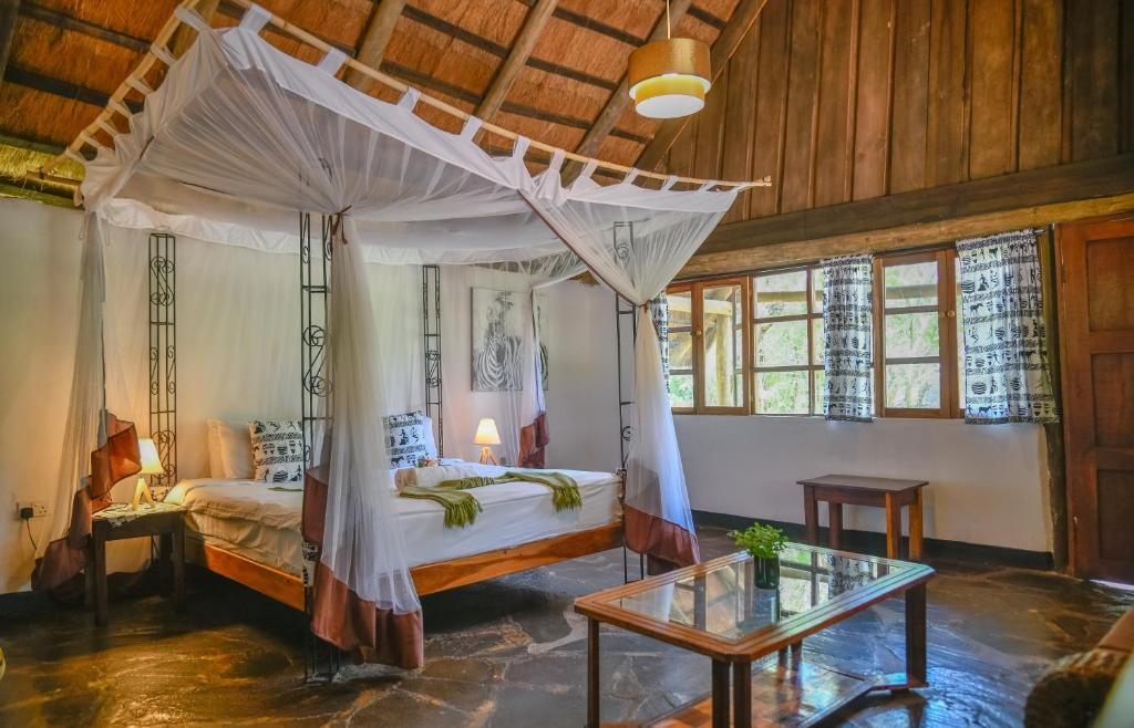 a bedroom with a canopy bed and a table at Pioneer Camp in Lusaka