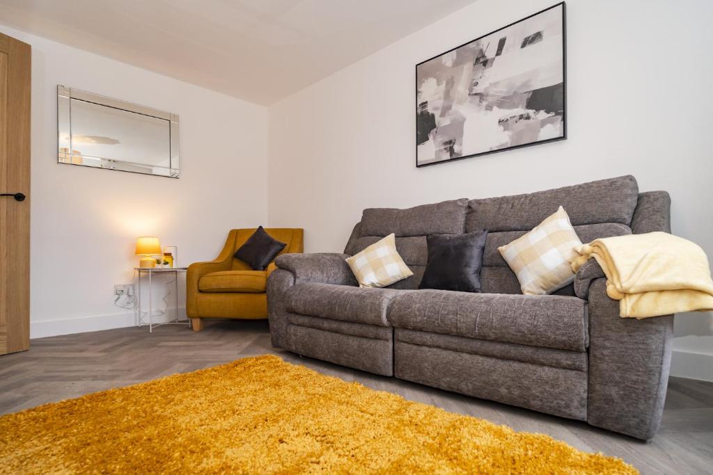 a living room with a couch and a yellow chair at Willow retreat in Royal Tunbridge Wells