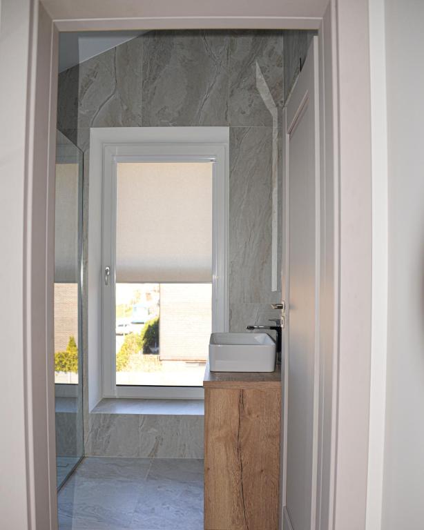 a bathroom with a window with a window blind at Prie jūros in Melnragė