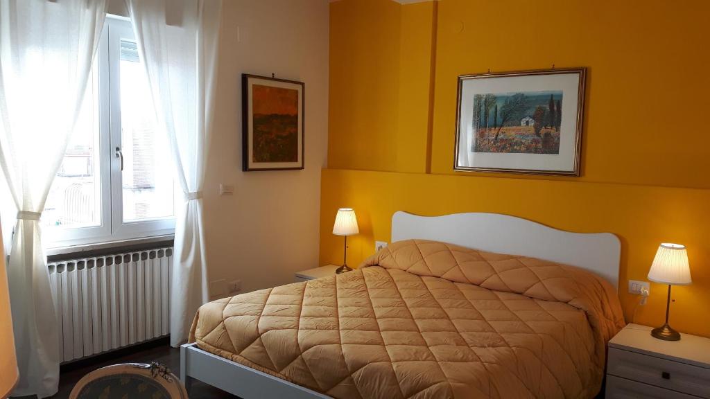 um quarto com uma cama com paredes amarelas e uma janela em BB Sesto Piano em Foggia