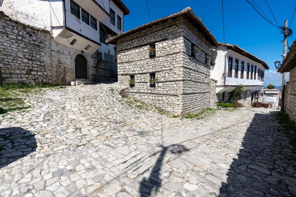 a shadow of a building on a cobblestone street at Villa Kokoshi, an extraordinary experience. in Berat