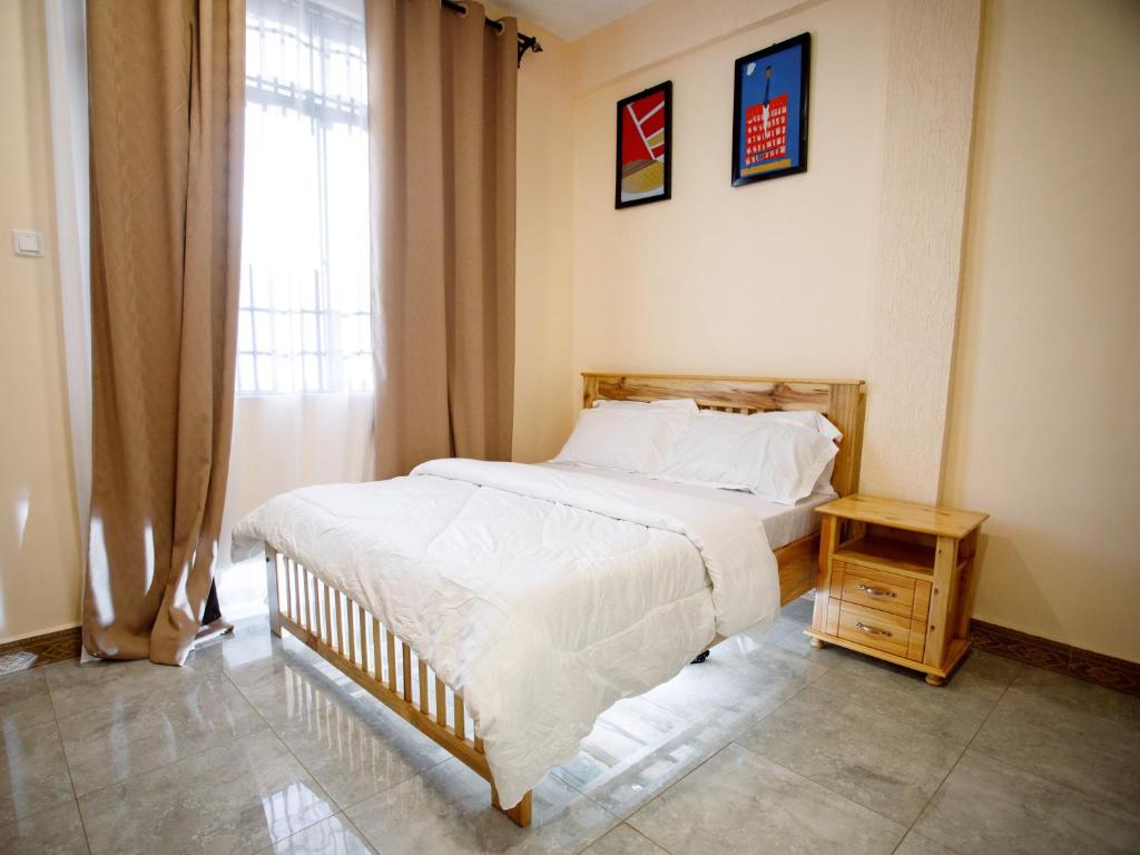 a bedroom with a large bed and a window at Kili Tanzania in Moshi