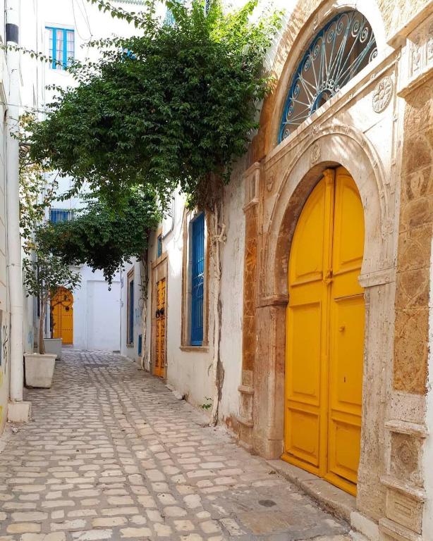 an alley with yellow doors on a building at Dar Haroun Tunis in Tunis