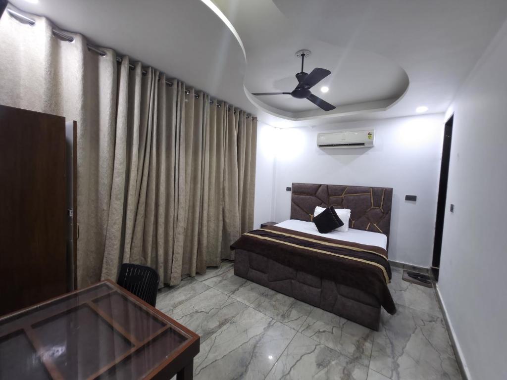 a bedroom with a bed and a ceiling fan at The Redcarmine in New Delhi