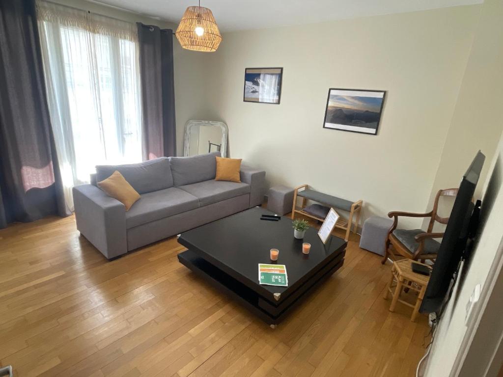 a living room with a couch and a table at Le Sam in Brive-la-Gaillarde