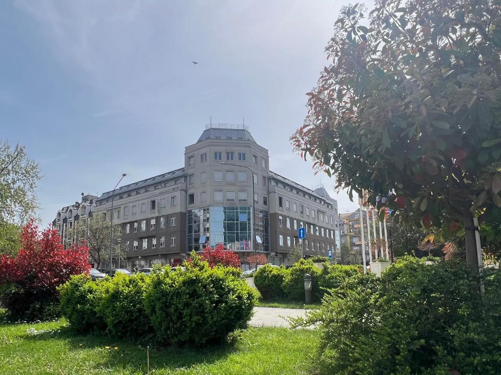 a large gray building with bushes in front of it at Stan na dan Flower in Šabac