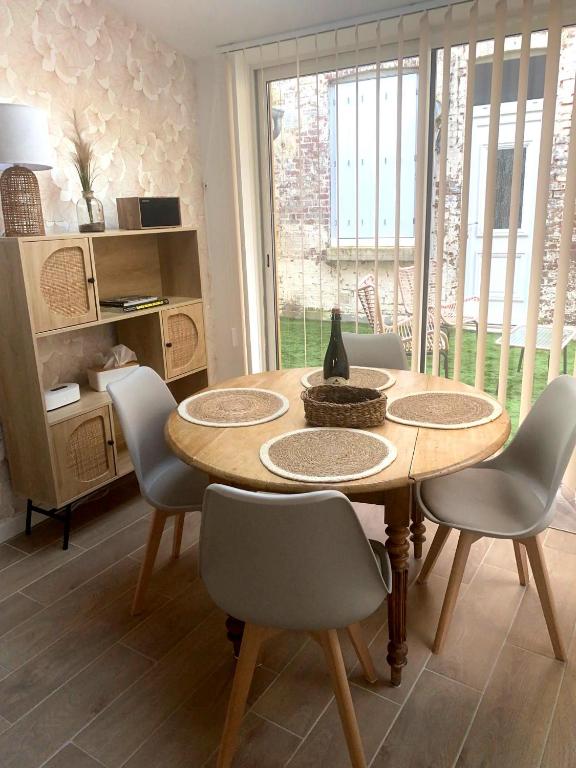 a dining room with a wooden table and chairs at L'effet Mer in Fécamp