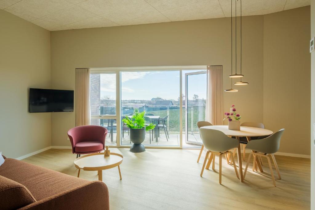 a living room with a couch and a table and chairs at Aalborg Hotel Apartments in Aalborg