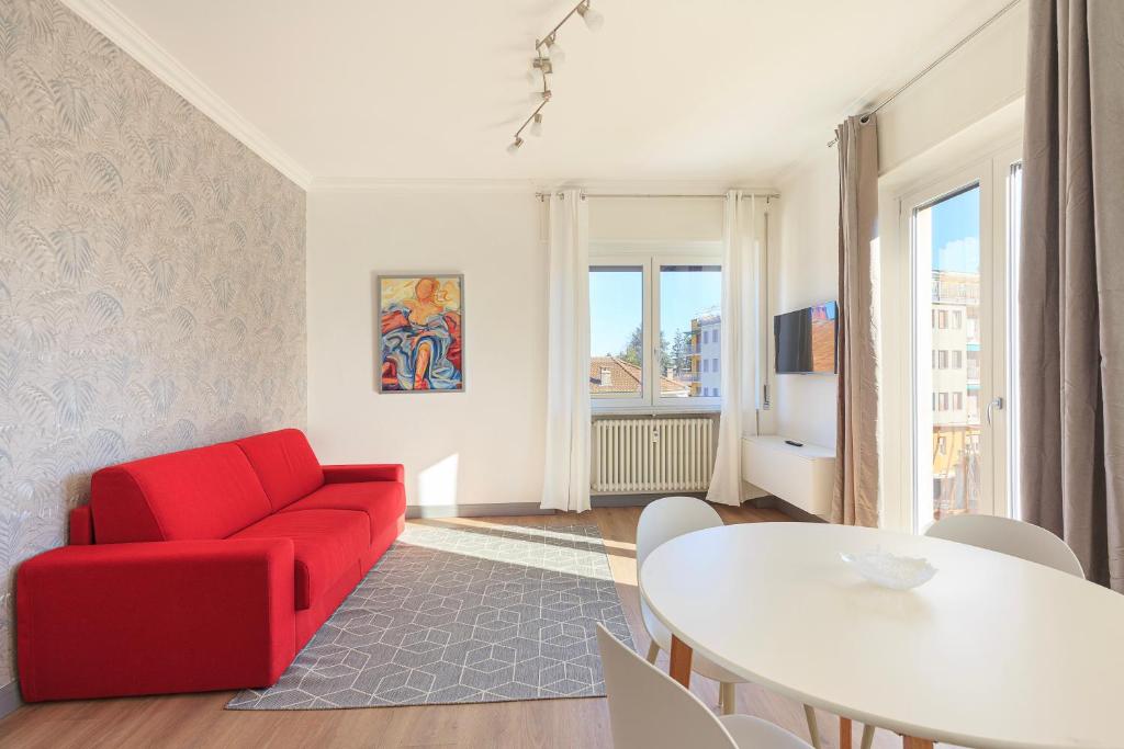 a living room with a red couch and a table at Lexia Suite in Lesa