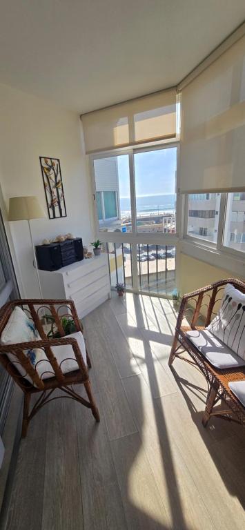 a living room with two chairs and a balcony at Casa Mar in Costa da Caparica