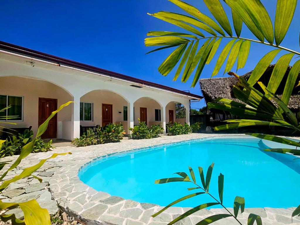 a swimming pool in front of a house at Mangoverde Guesthouse in Moalboal