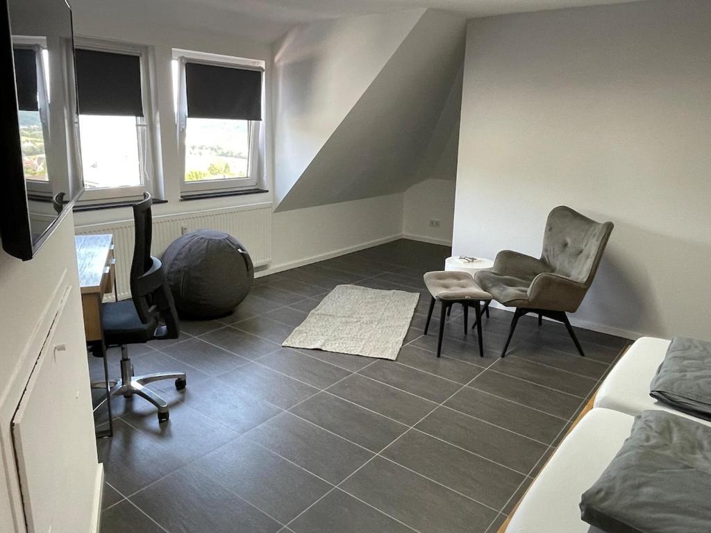 a room with two chairs and a desk and a bed at Modernes Apartment in Haiger Allendorf in Haiger