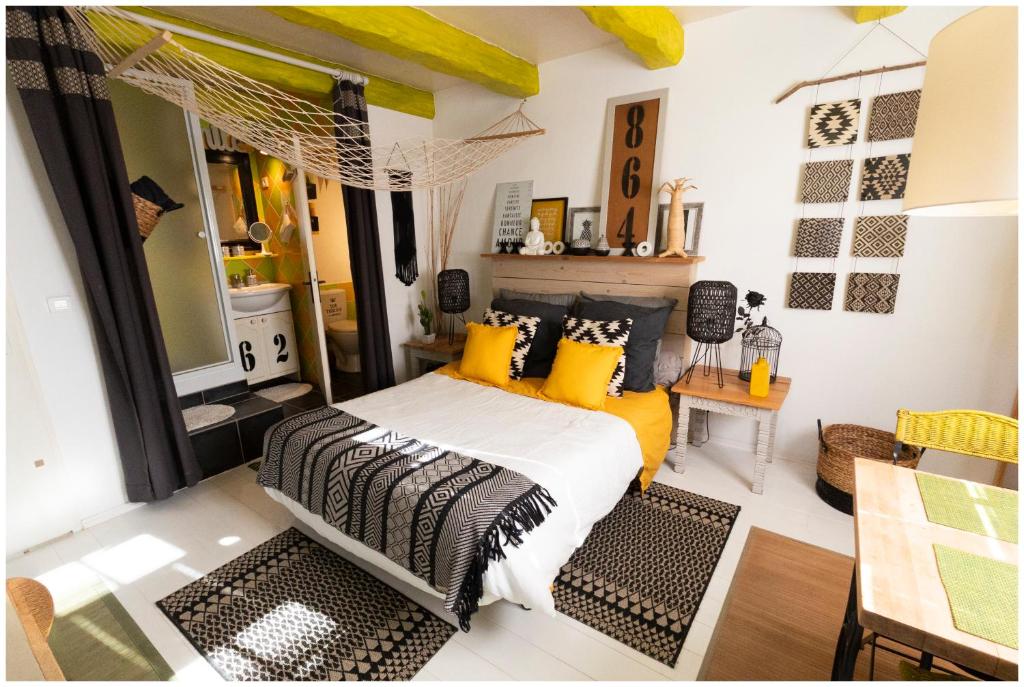 a bedroom with a bed with yellow and black pillows at La Joliette in Junas