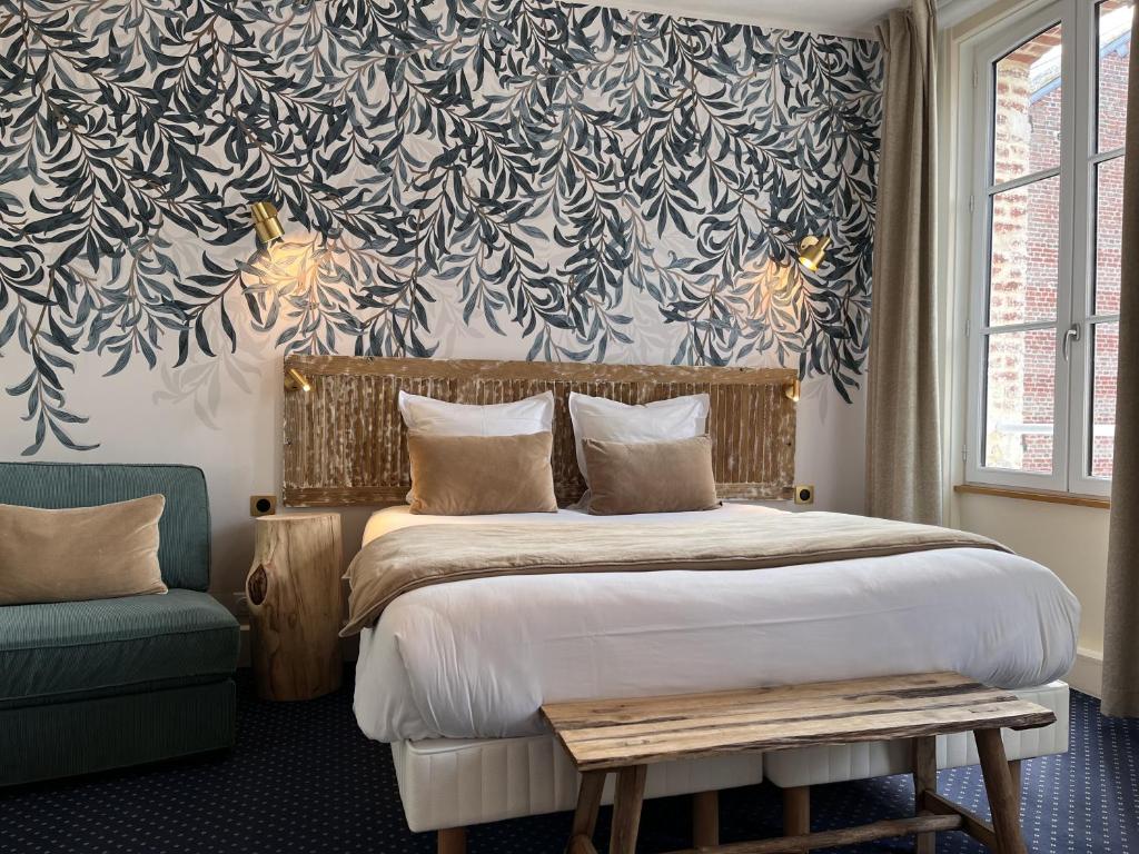 a bedroom with a large bed with a floral wallpaper at Le Trouville - Hôtel de Charme in Trouville-sur-Mer