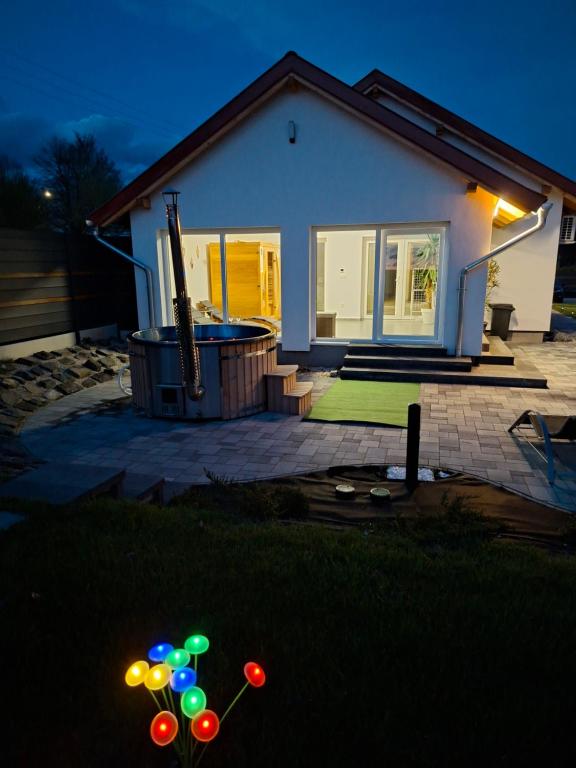 a house with a pool and balloons in the yard at Napsugár Wellness Apartman in Újudvar
