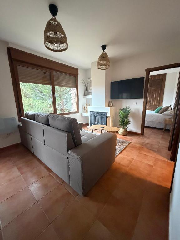 a living room with a couch and a fireplace at Atempo Berzosa Arce in Berzosa del Lozoya