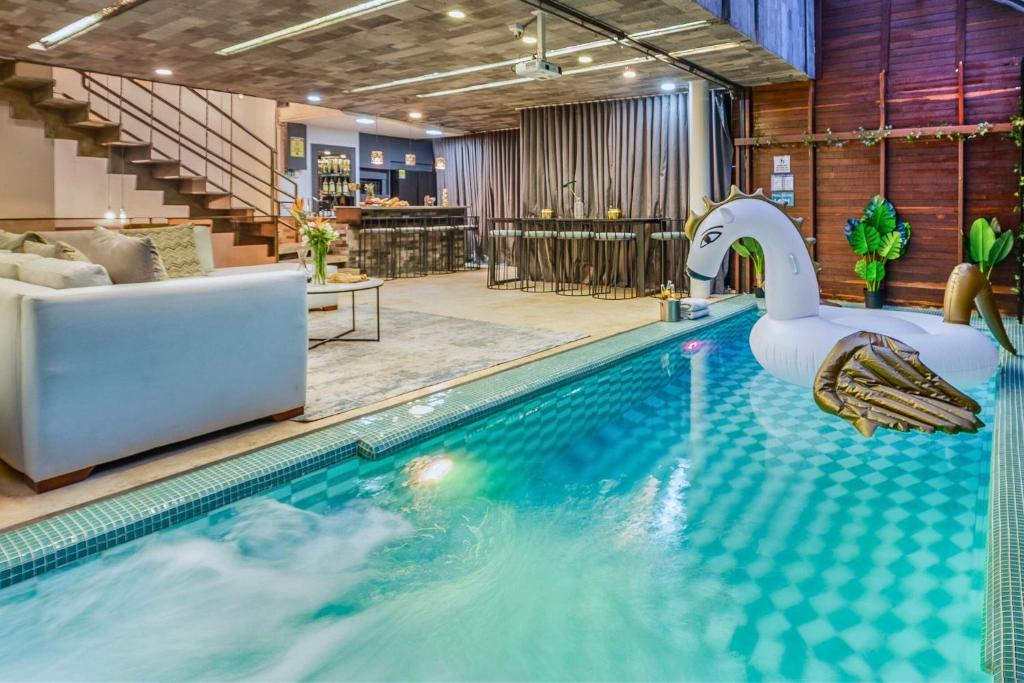 a swimming pool with a swan in a hotel room at Ultimate 9BR Lleras Villa W Heated Pool in Medellín
