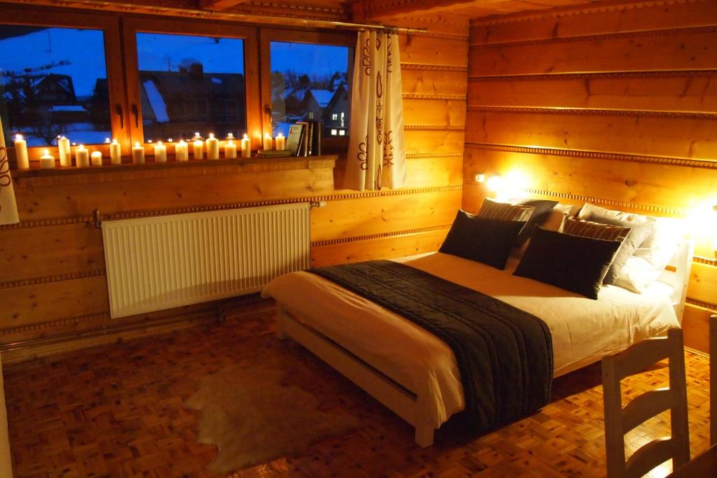 a bedroom with a bed with lights and a window at Spiski Apartament in Łapsze Niżne