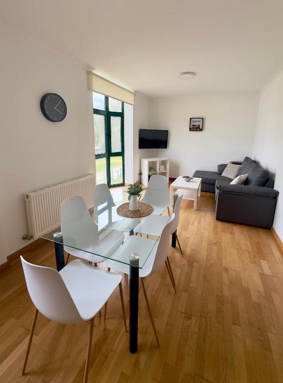 a living room with a couch and a table and chairs at PortoHome 1 in Portomarin