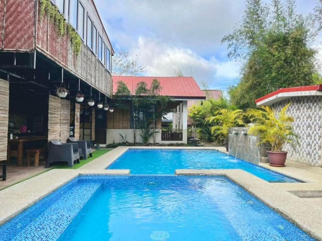 a swimming pool in front of a house at Soulelle Villa in Silang