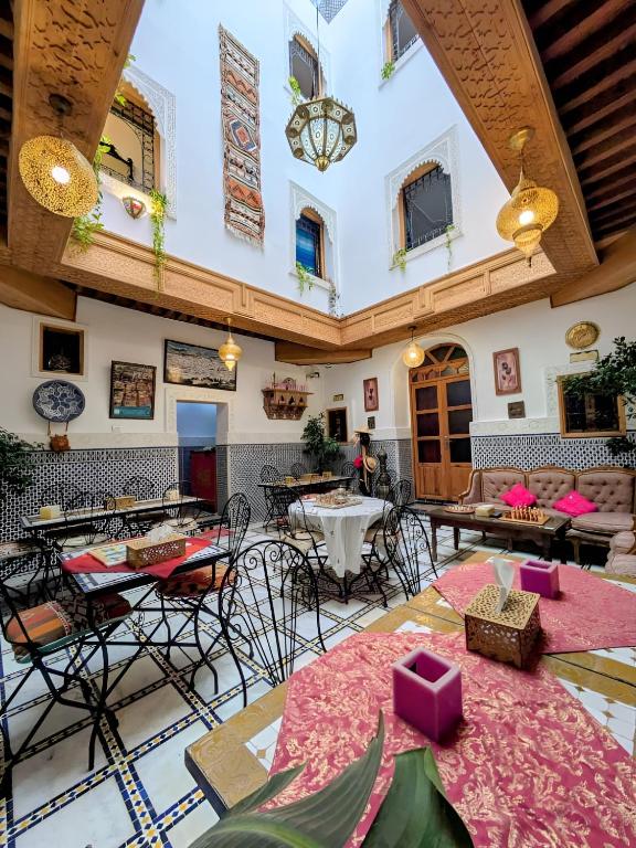 a large room with tables and chairs in a building at Riad Tafoukt Palace in Fez