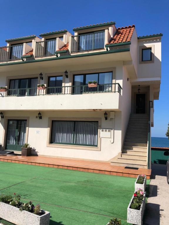 a large house with a lawn in front of it at DUPLEX JUNTO AL MAR in Oia