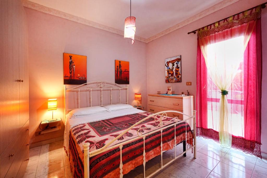 a bedroom with a white bed and a window at Armonia del Mare in Mascali