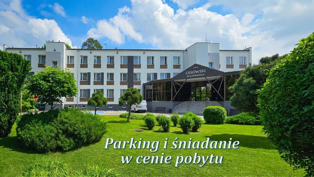 a large white building with a lawn in front of it at Hotel Ossowski in Swarzędz