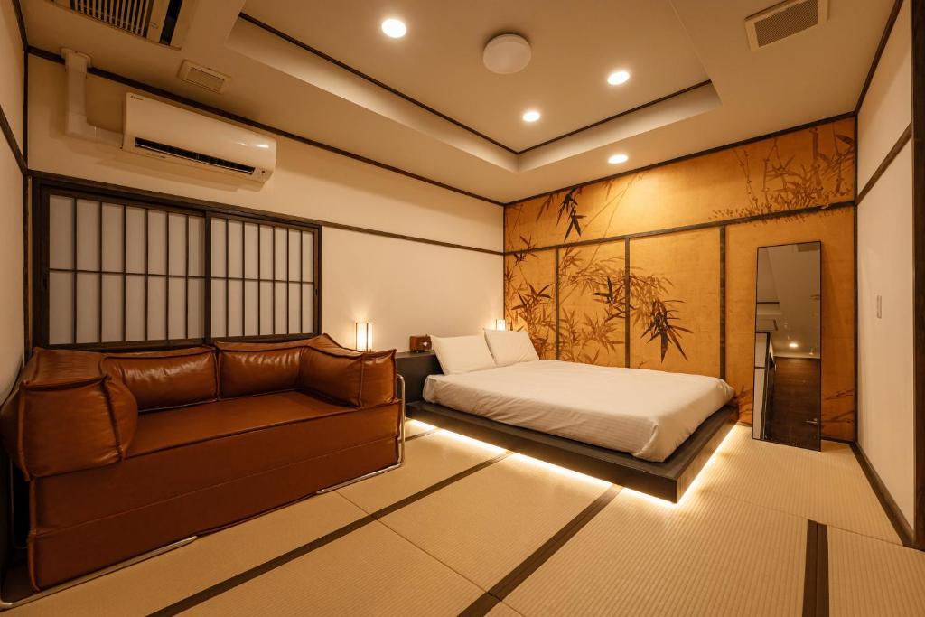 a bedroom with a bed and a couch at oyasumi hotel 道頓堀 Zero-pressure mattress in Osaka