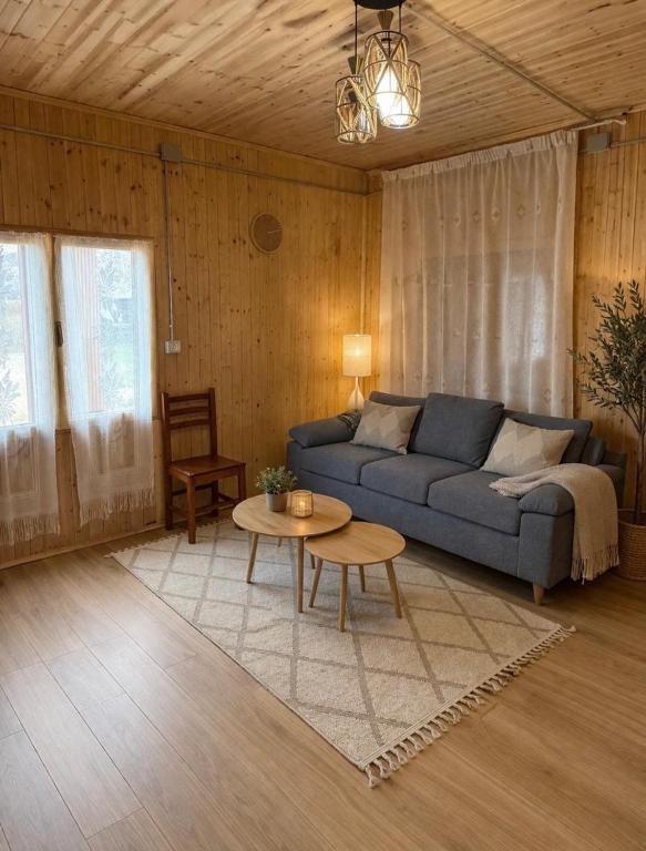 a living room with a couch and a table at Shpija Ujevara e Vogel 2 in Theth