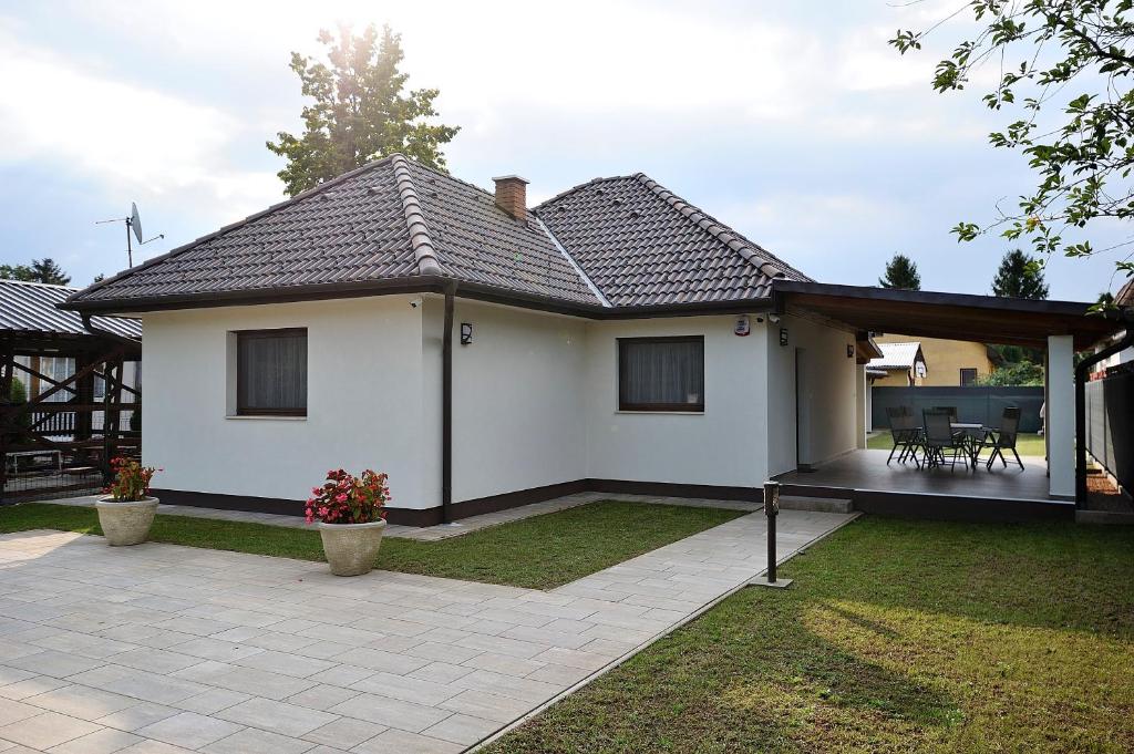 a white house with a pavilion in a yard at Laura Villa in Balatonlelle