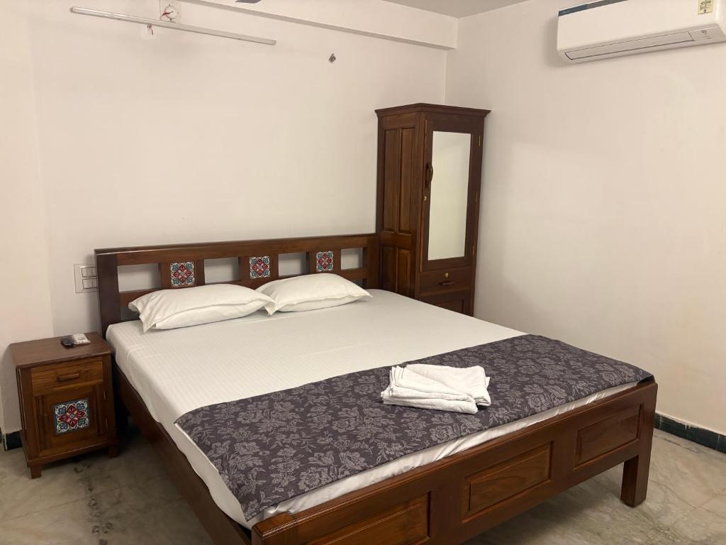 a bedroom with a bed with a dresser and a mirror at Rainbow721 Earth in Pondicherry
