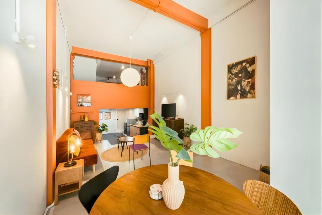 a living room with a table with a vase on it at Industrial Loft Sukhumvit 3-Bedroom Designer House - 2 Min to BTS Bang Chak in Bangkok