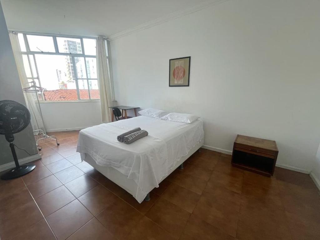 a bedroom with a white bed and a window at Quarto privado a 160 metros da Praia do Farol da barra 1 in Salvador