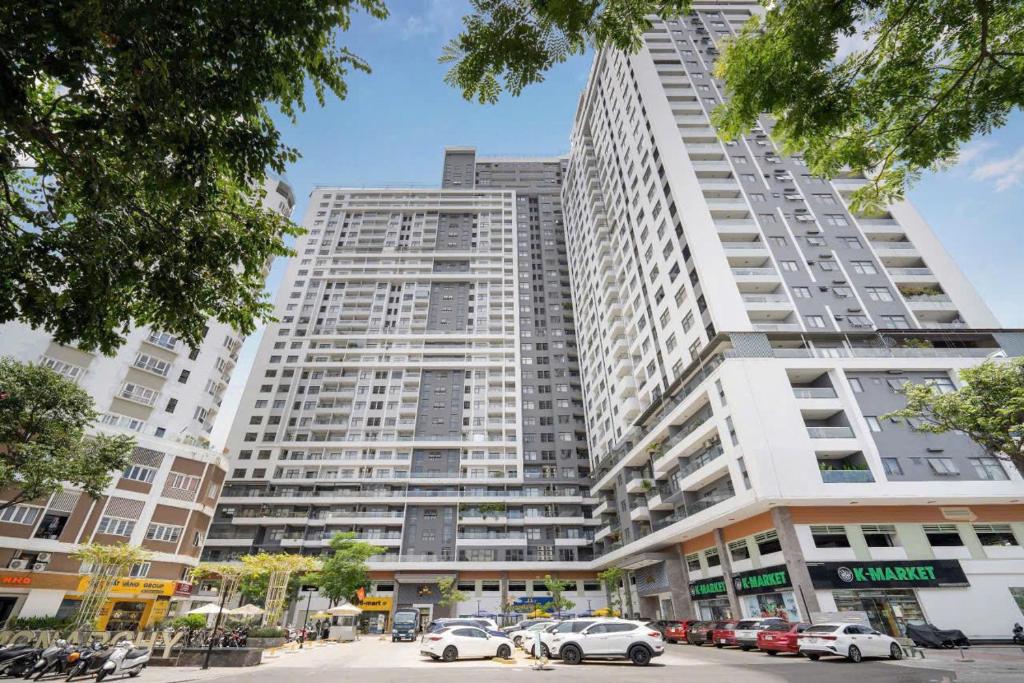 a large white building with cars parked in front of it at Monarchy Luxury Serviced Apartments - By Charm Homestay Vietnam in Danang