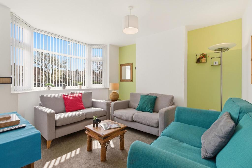 a living room with two couches and a table at 4BR with Private Parking in Wyken