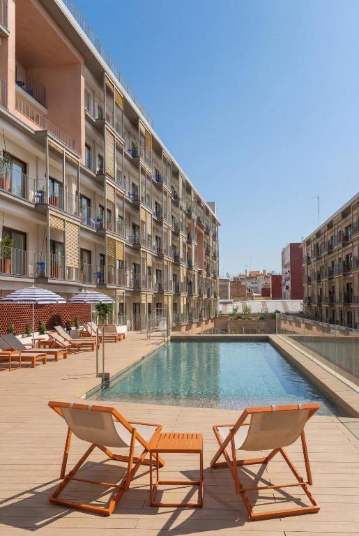 ein Hotel mit Swimmingpool und zwei Liegestühlen in der Unterkunft Kora Lluna in Valencia