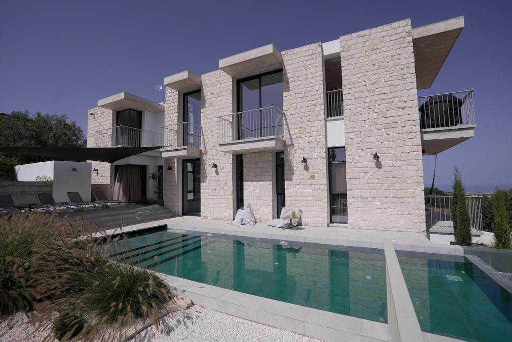 a house with a swimming pool in front of it at Stylish Villa, Rural Setting, Infinity Pool in Pano Akourdalia
