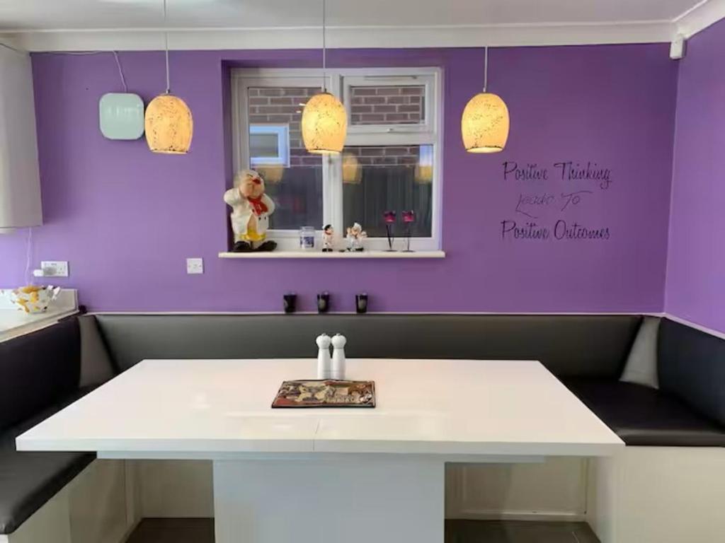 a kitchen with a white table and purple wall at Double room in Reading in Earley